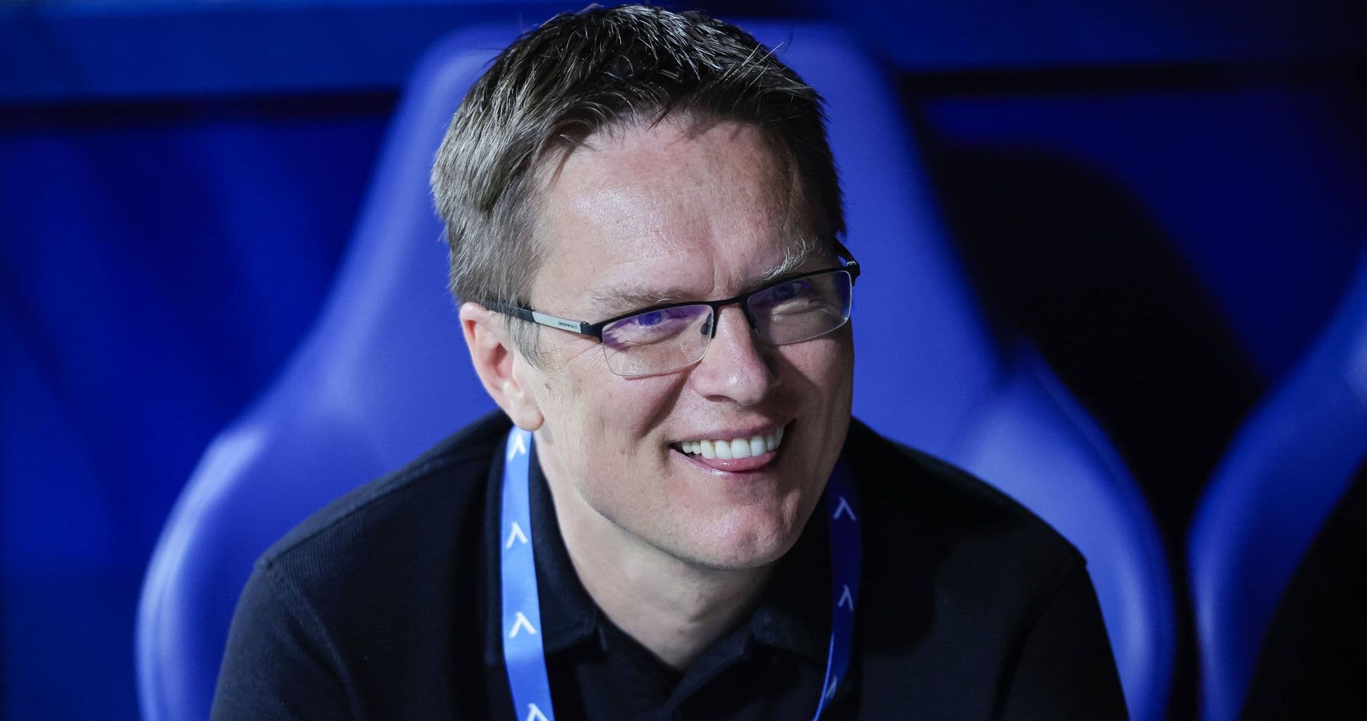 Man smiling in a sports venue seat