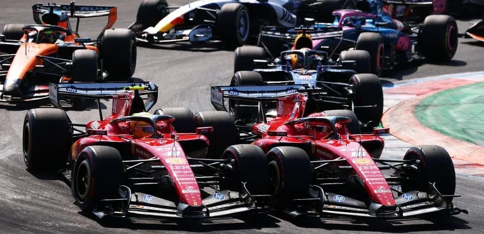 Two Ferrari cars racing closely during Formula 1 event