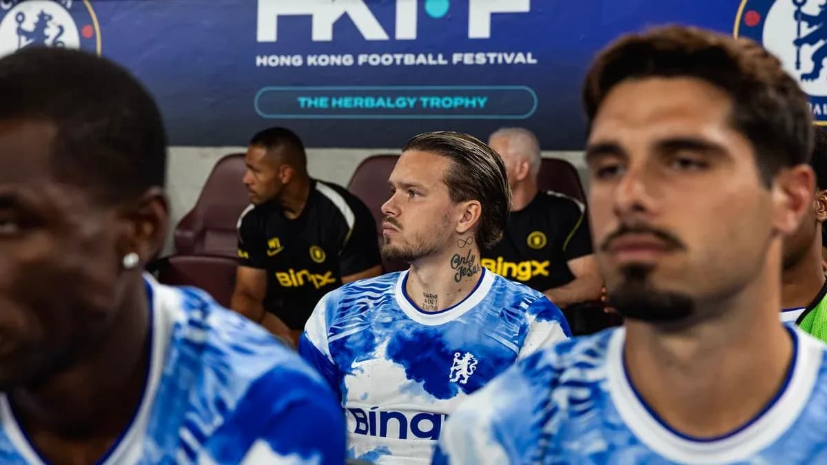 Chelsea players seated on bench during match