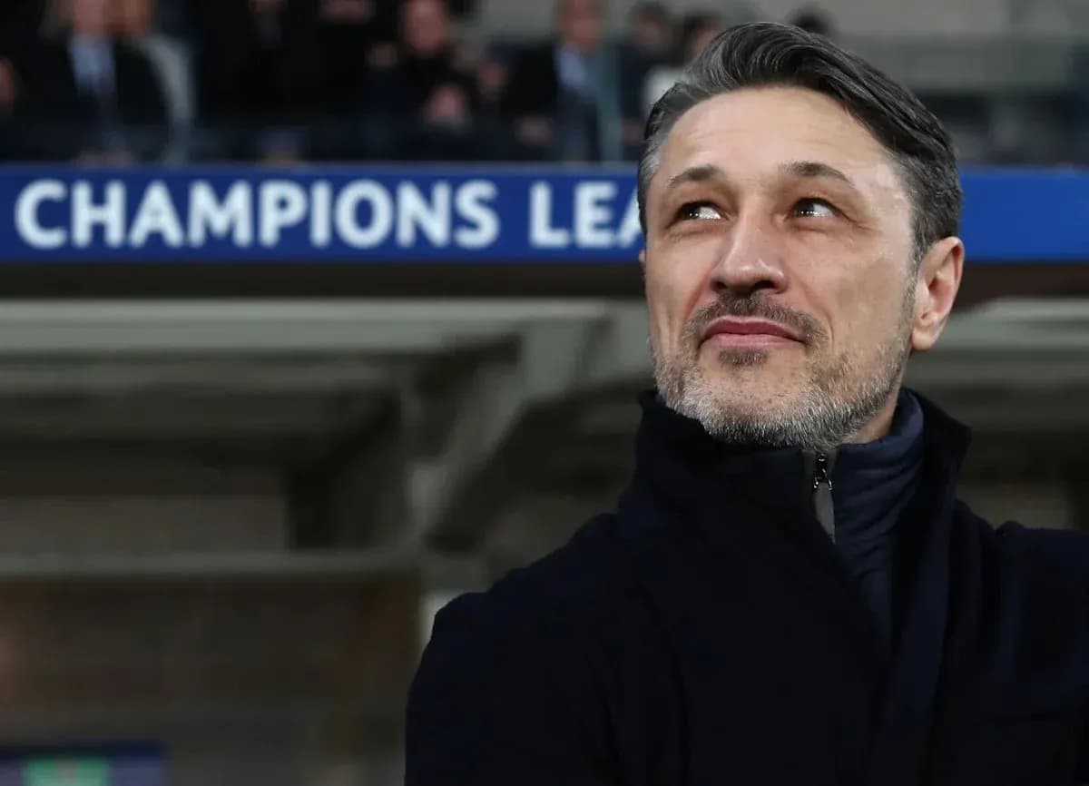 Coach observing match with Champions League banner above