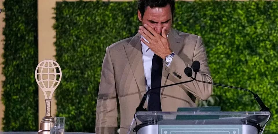 Tennis player at podium with trophy, visibly emotional