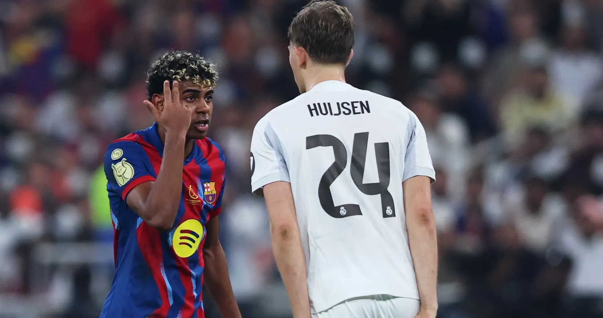 Barcelona player gesturing at Real Madrid opponent