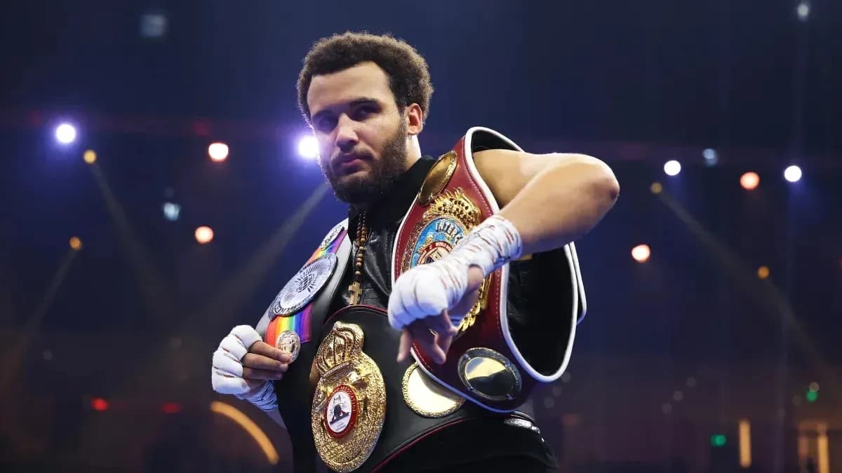 Boxer displaying championship belts in the ring