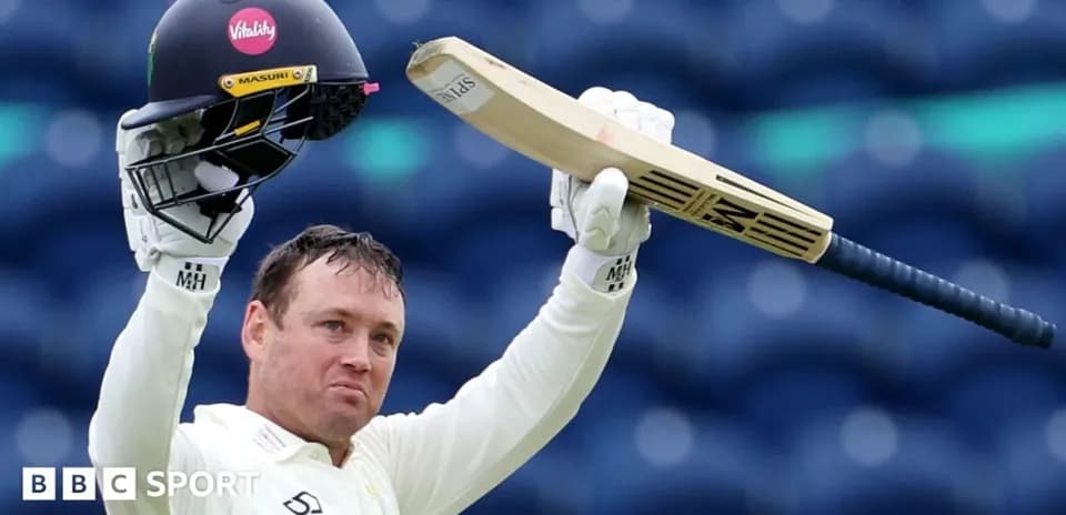 Batsman raising bat and helmet in celebration