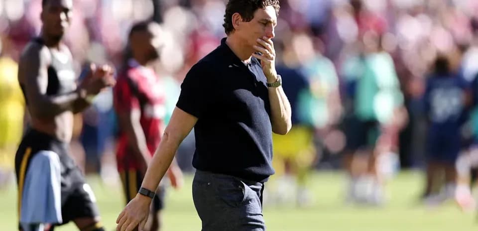 Coach walking off the pitch after match