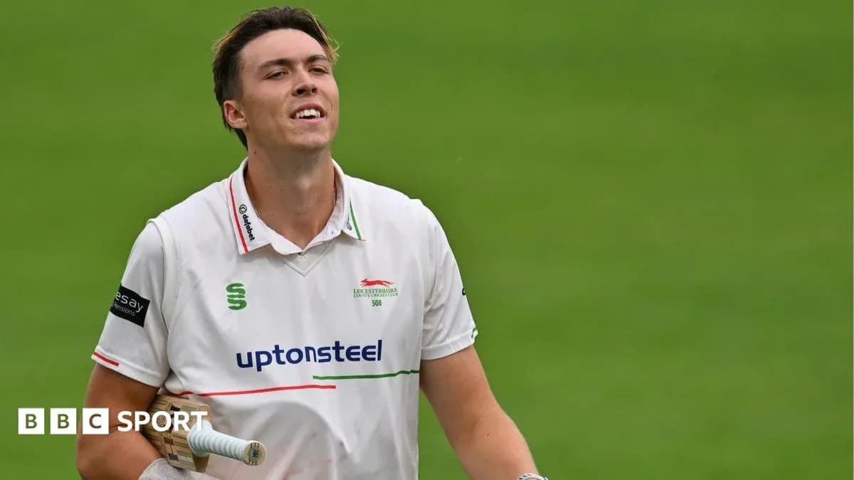 Cricketer walking off field with bat in hand