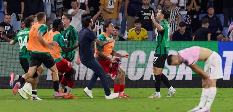 Players celebrating a goal in front of fans