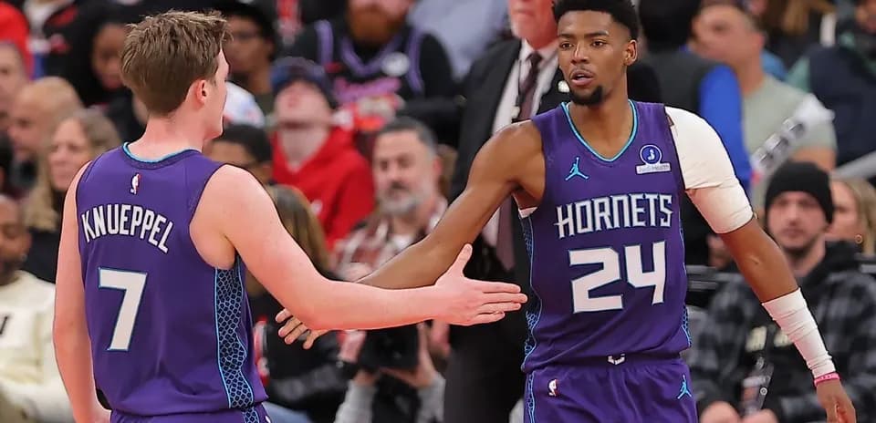 Two Charlotte Hornets players high-fiving during game