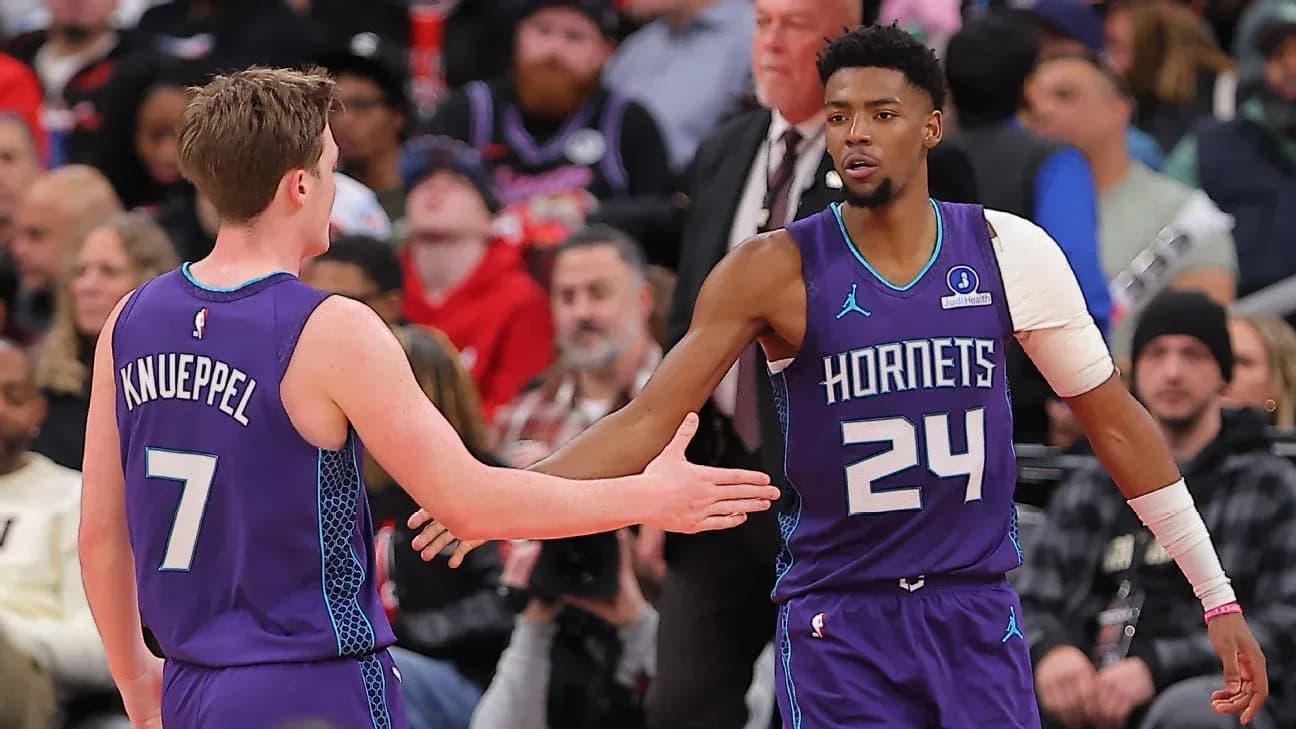 Two Charlotte Hornets players high-fiving during game