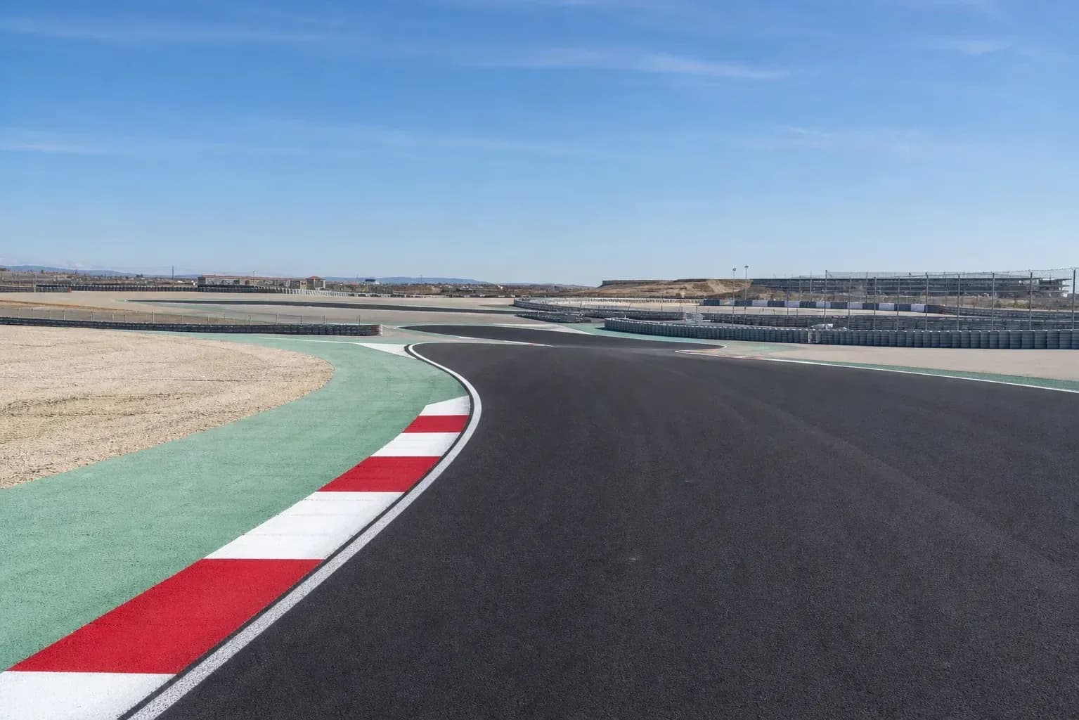 Curved racetrack with colorful curbing and surroundings