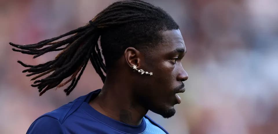 Player with long hair and earrings during warm-up