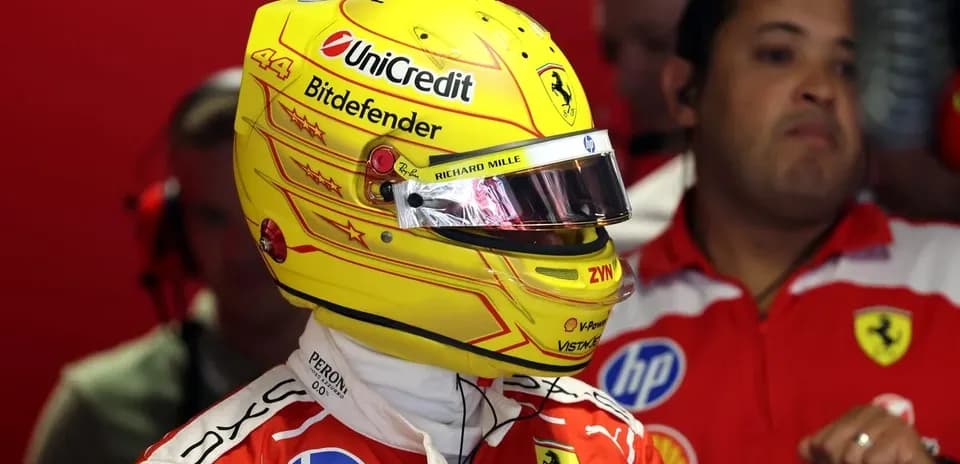 Driver wearing helmet in Ferrari pit garage
