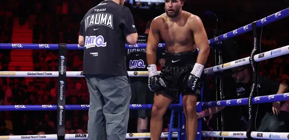 Boxer receiving advice from coach in corner