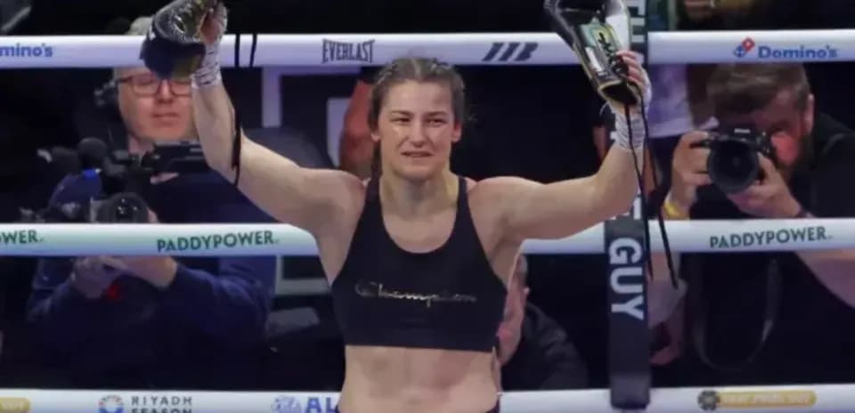 Boxer celebrating victory with gloves raised in ring