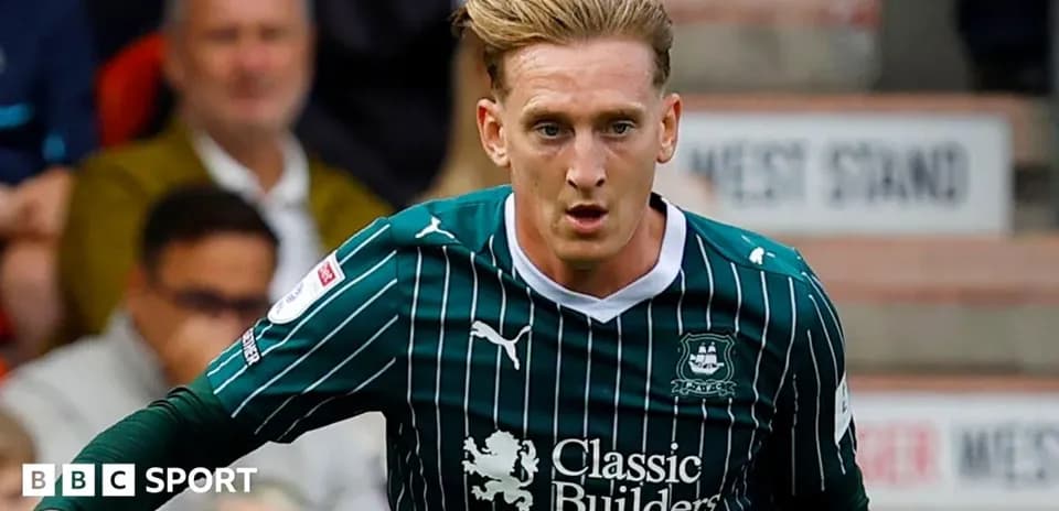 Player running during a football match in green kit