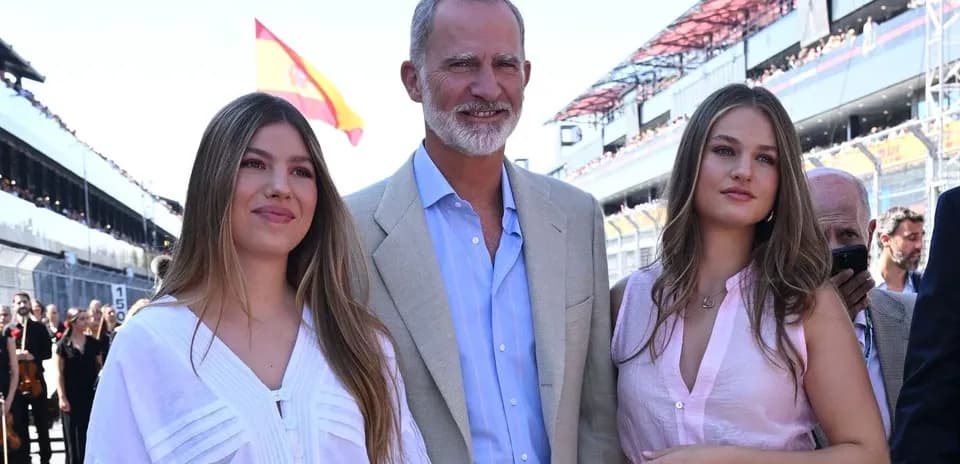 Group posing at a motorsport event with Spanish flag