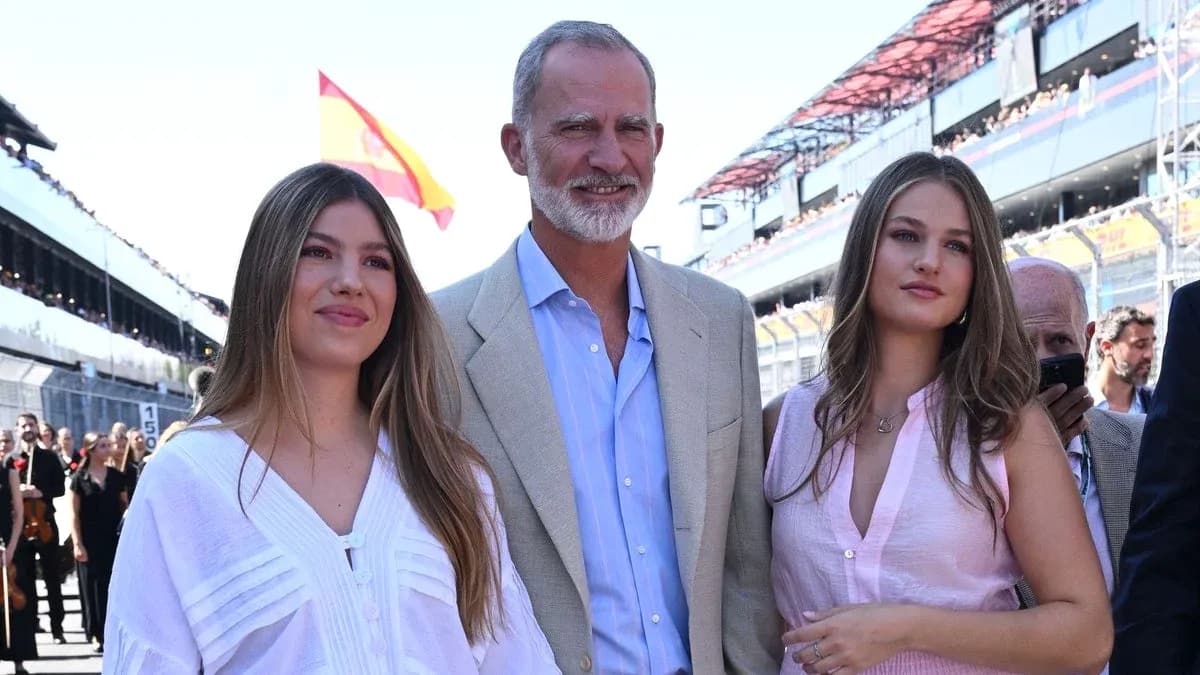 Group posing at a motorsport event with Spanish flag