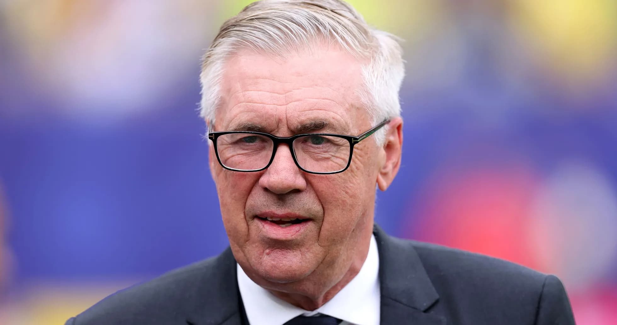 Coach with glasses standing on the sidelines