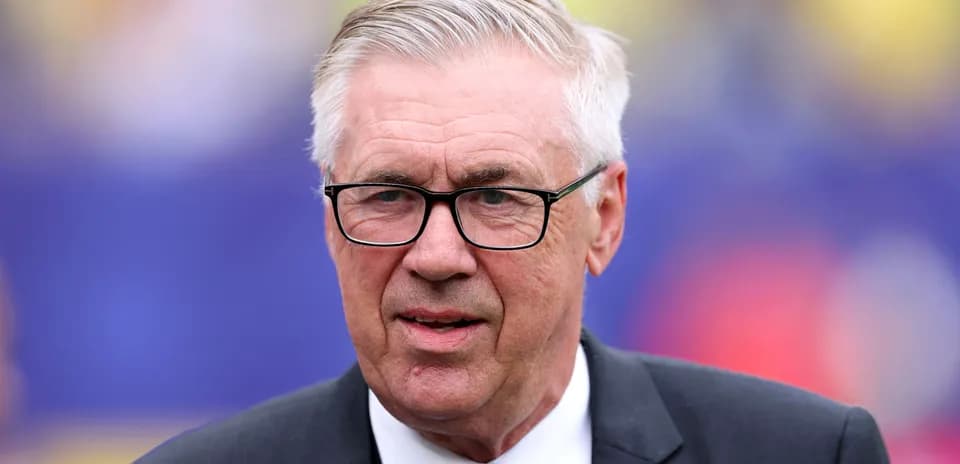 Coach with glasses standing on the sidelines