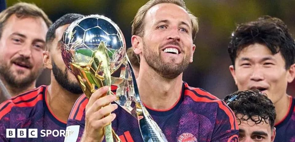 Player holding trophy with teammates celebrating