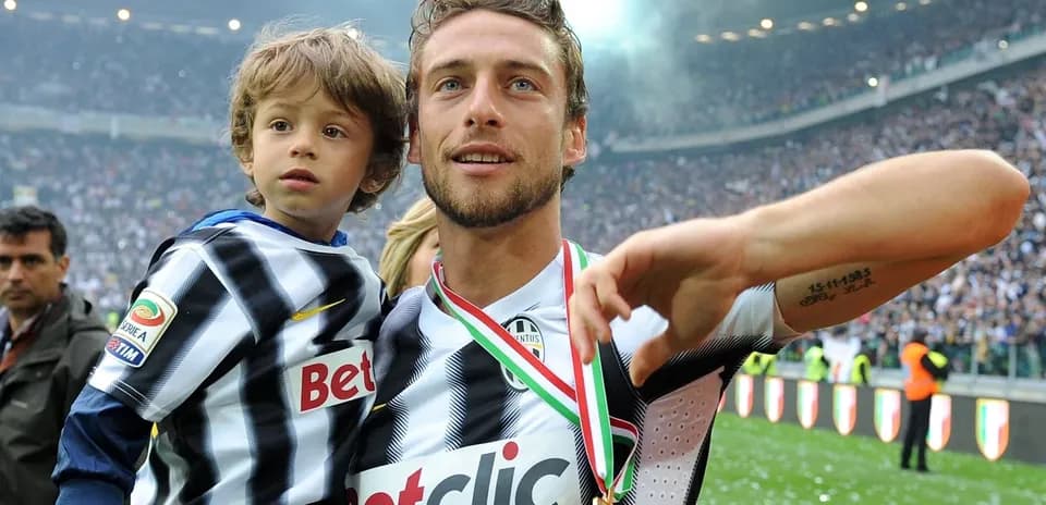 Player celebrating with child and medal on field