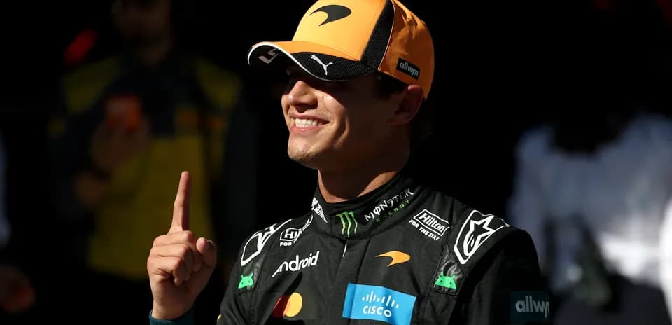 Driver celebrating with finger raised in pit area