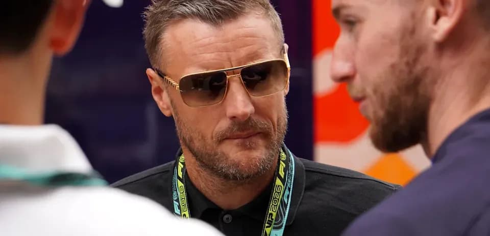 Man wearing sunglasses talking to two others