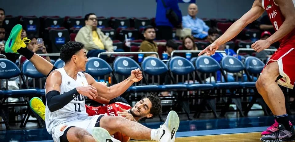Players on the floor competing for the basketball