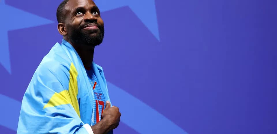 Athlete wearing a flag at an event backdrop