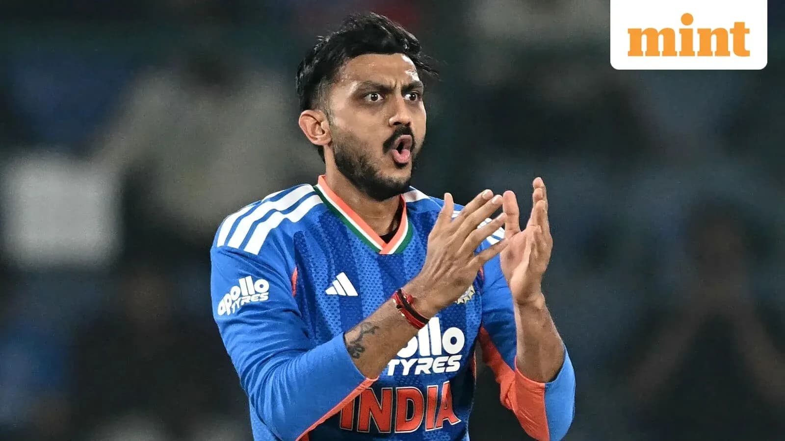 Cricketer in blue jersey clapping during match