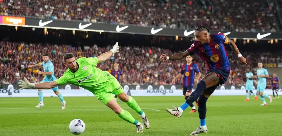 Barcelona player shoots as goalkeeper attempts to save