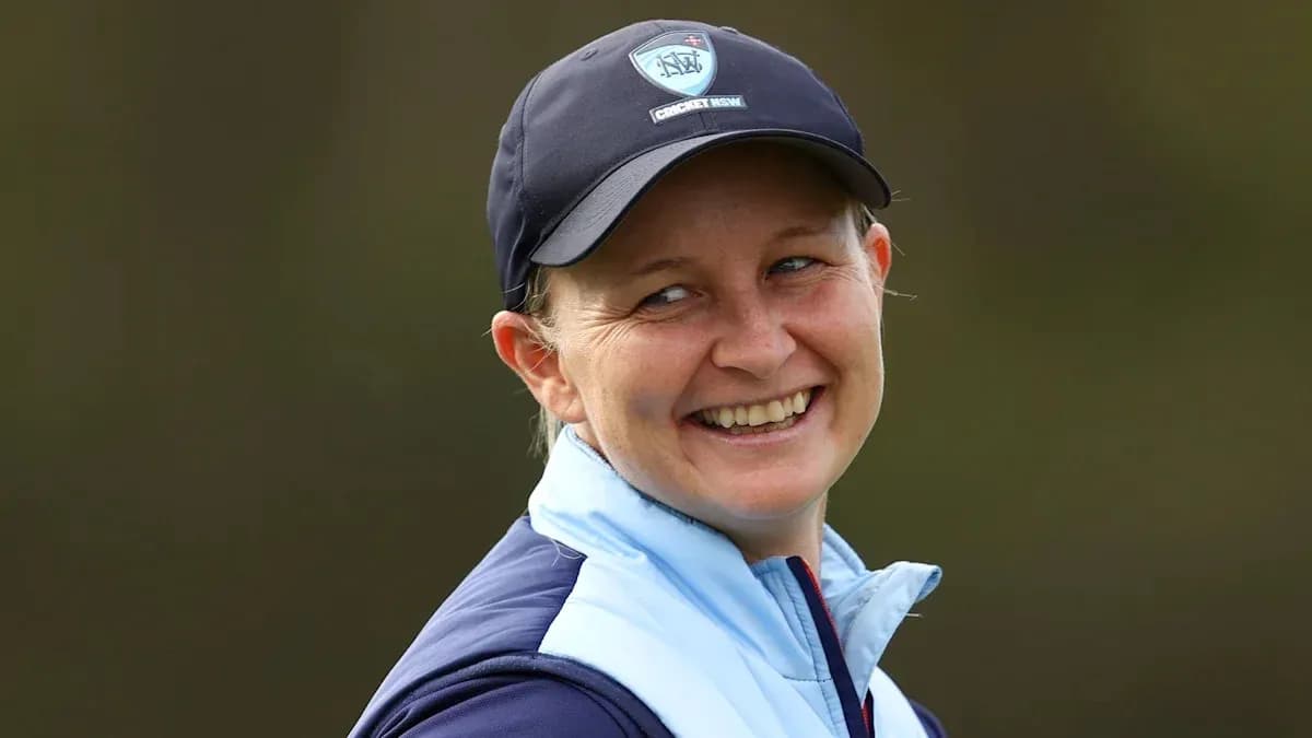 Smiling woman wearing cricket cap and jacket