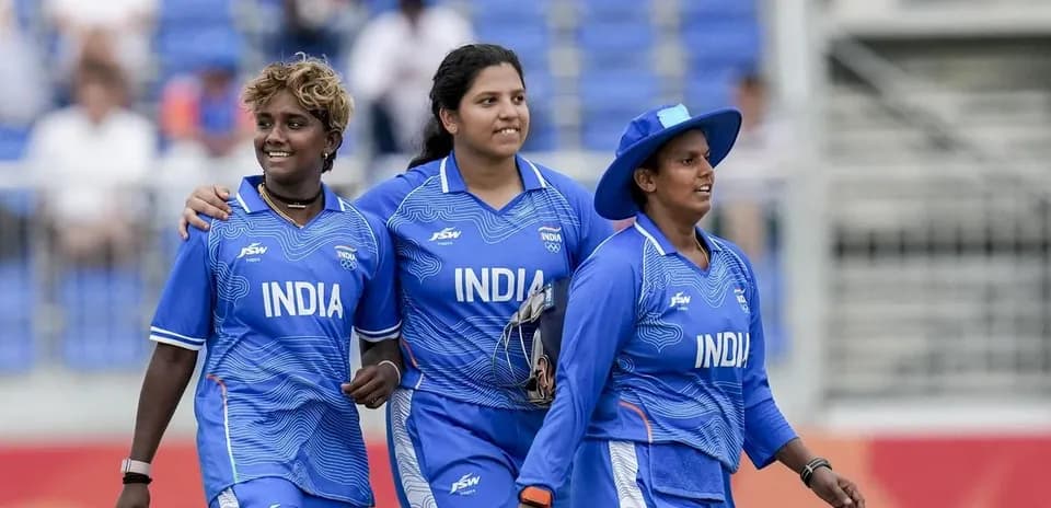 Three Indian women cricketers walking together on field