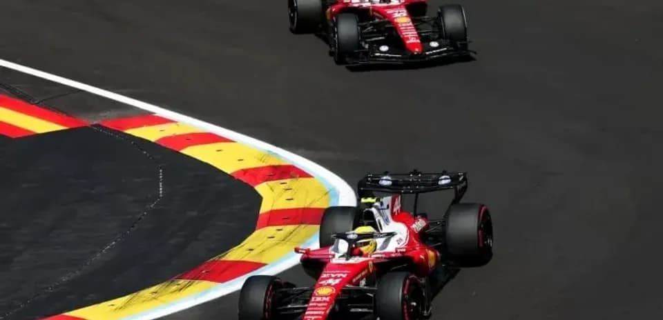 Two Ferrari cars navigating a corner on track