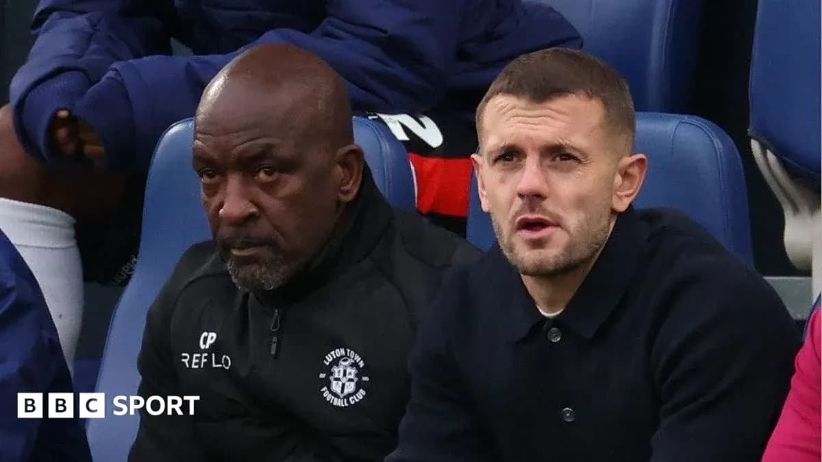 Two men seated on bench during football match