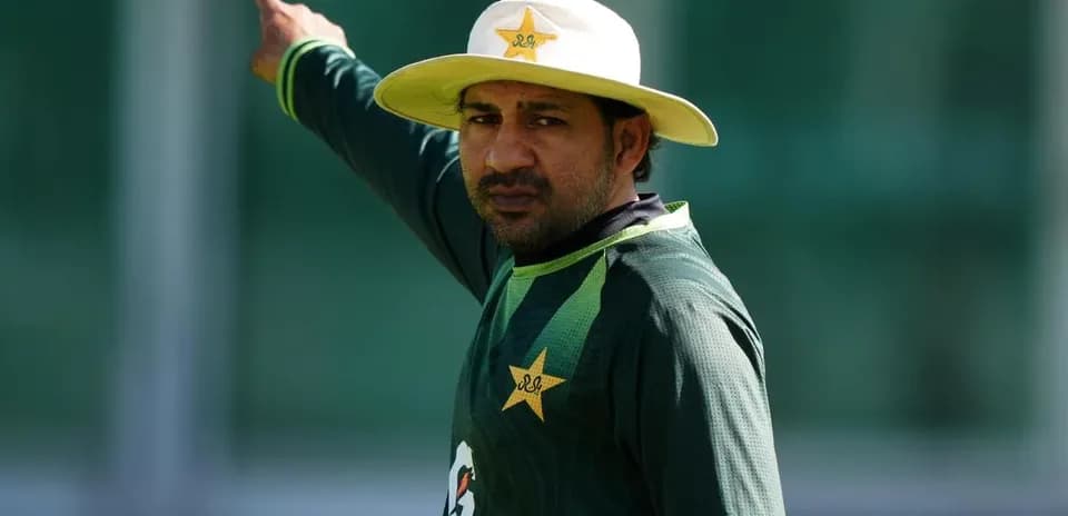 Cricketer signaling during training session in uniform