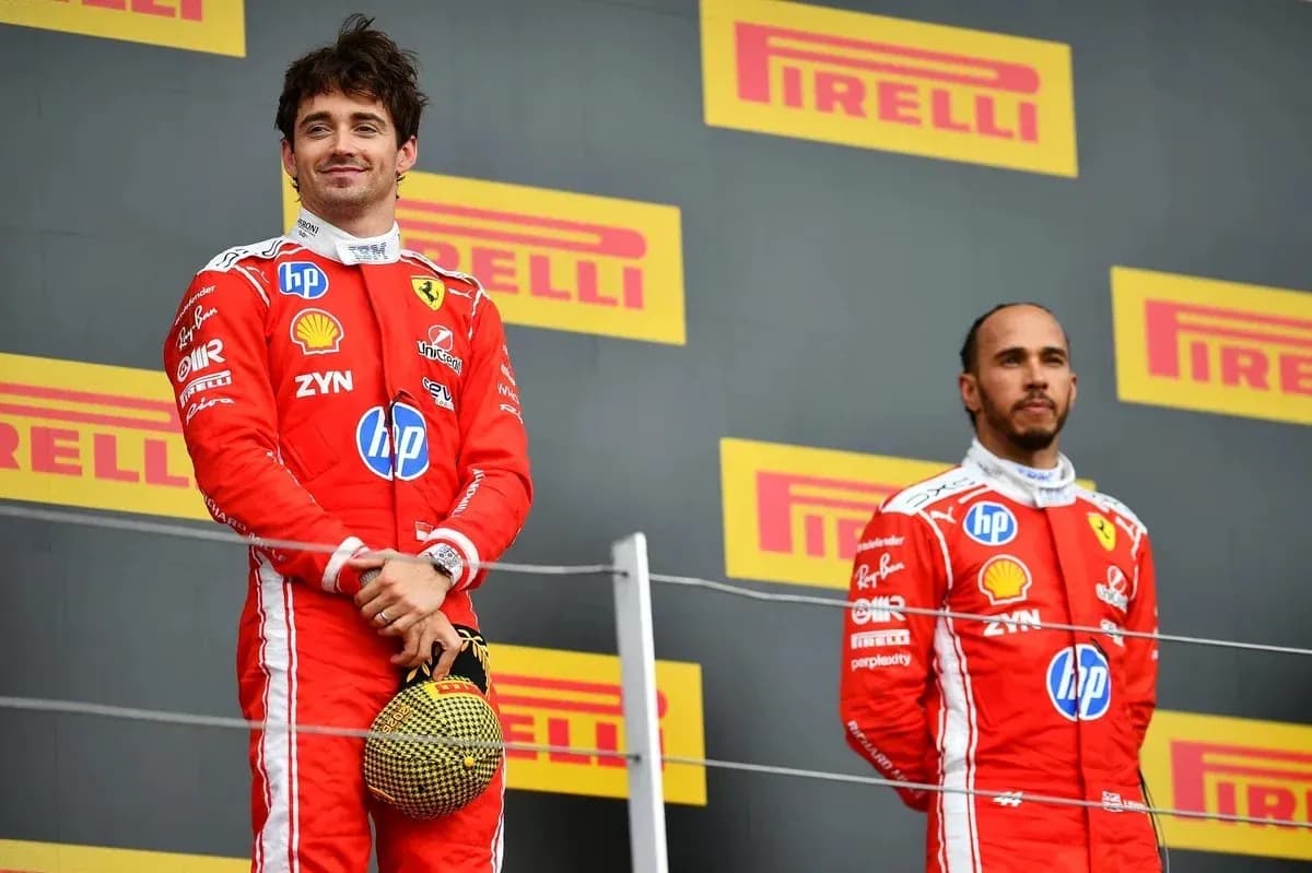 Two drivers on podium wearing Ferrari race suits
