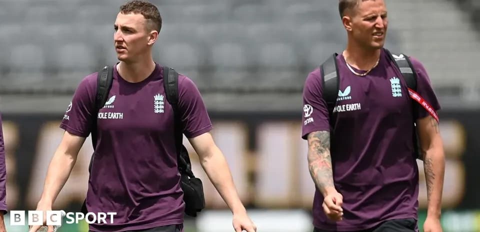 Two England cricket players walking on the field