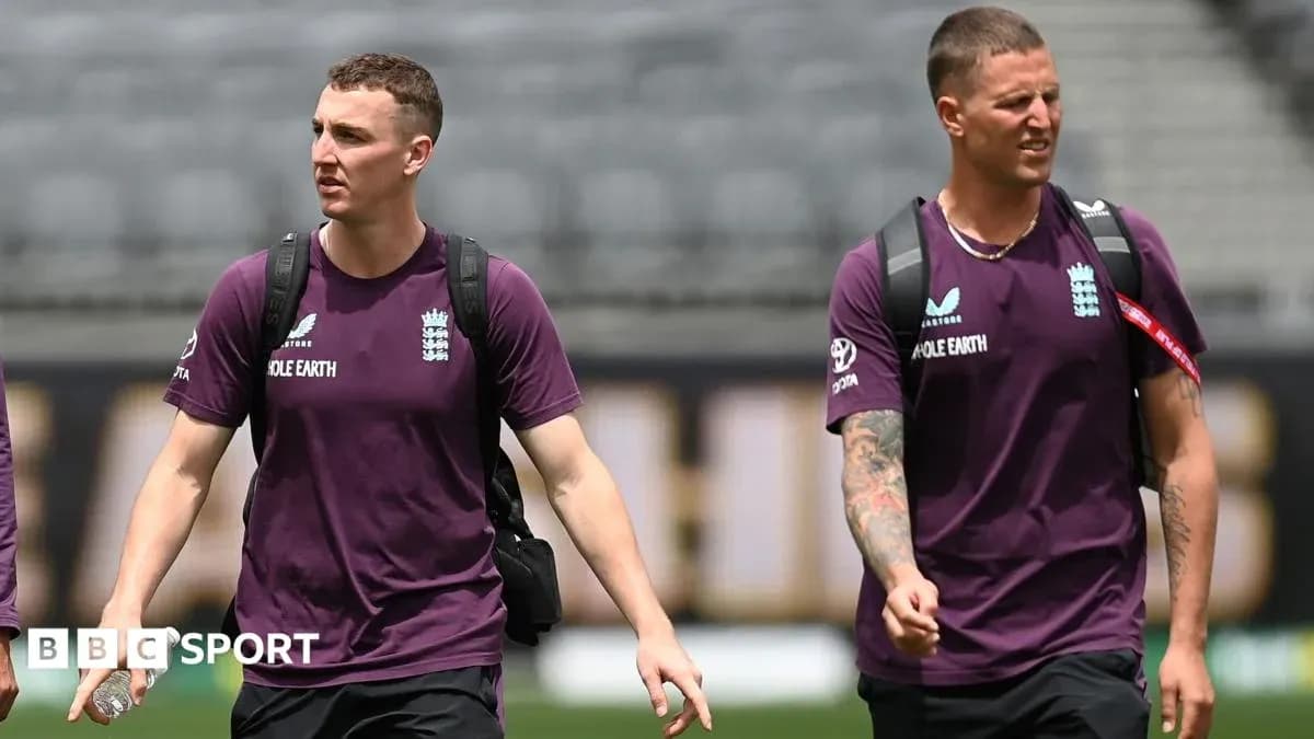 Two England cricket players walking on the field