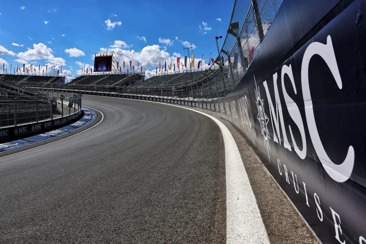 Curved racetrack with grandstands and blue sky