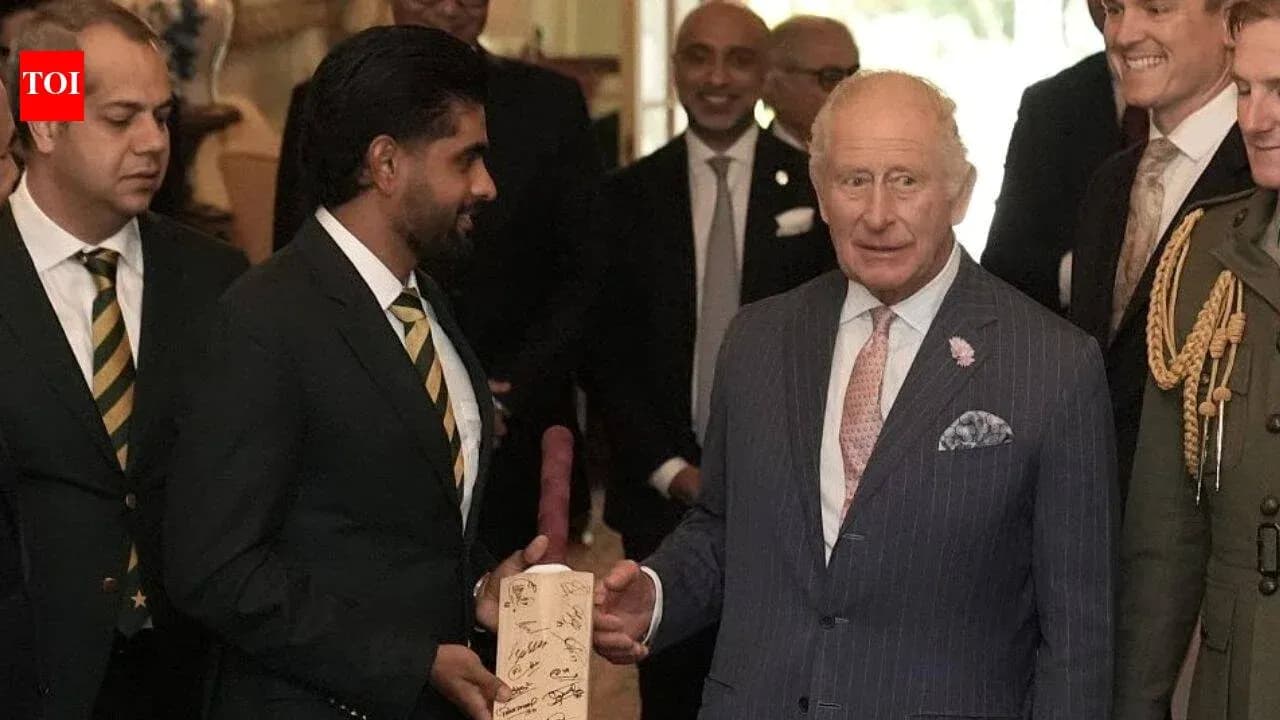 Cricketers presenting signed bat to King Charles
