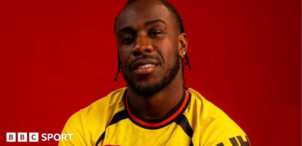 Player wearing Watford FC jersey against red background