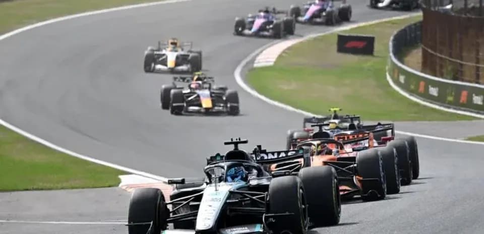 Formula 1 cars racing on a winding circuit