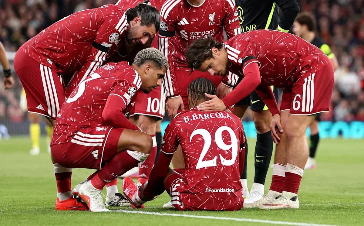 Liverpool players surrounding teammate on the ground