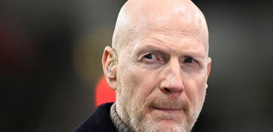 Bald man with earpiece looking intently