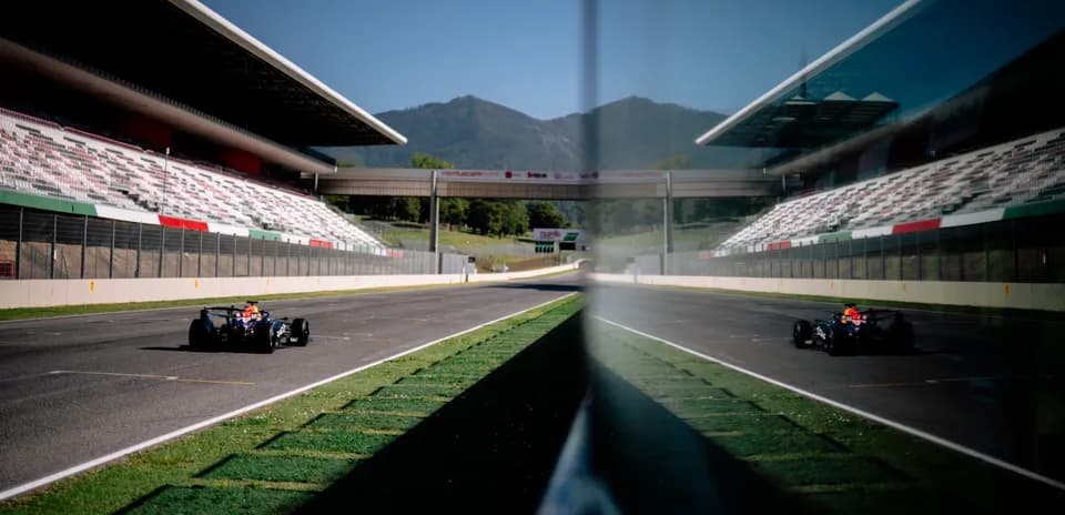 Race car driving on track with grandstand in background