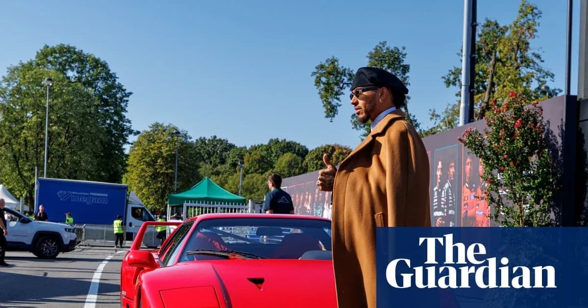 Person standing beside a red sports car outdoors
