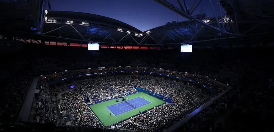 Night view of packed stadium during tennis match