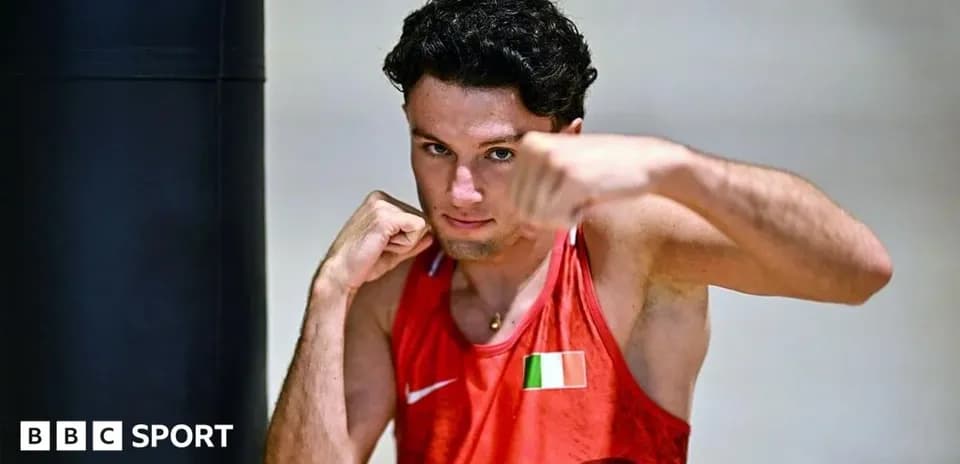 Boxer posing with gloves near training equipment