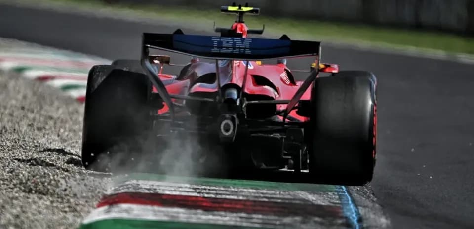 Red Formula 1 car on track with tire smoke
